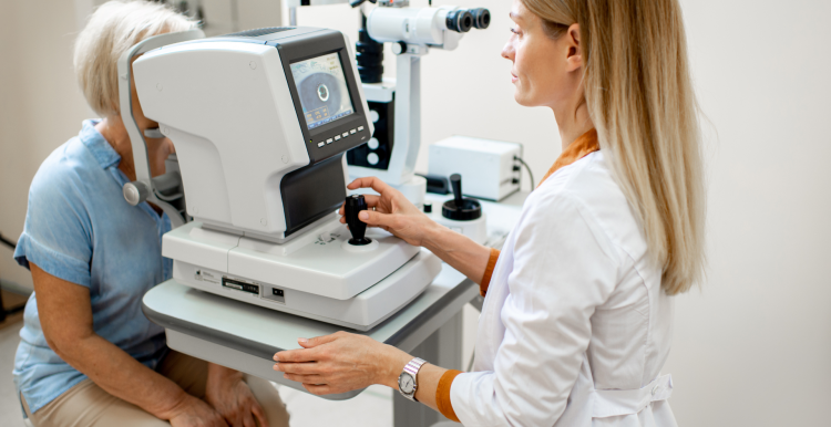 Ophthalmologist examining the eyes of an older patient using a digital microscope during a medical examination.