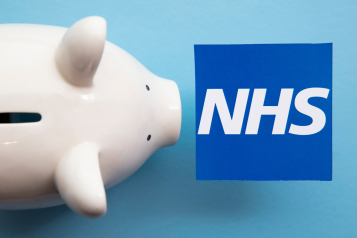 NHS logo on a blue background next to a piggy bank.