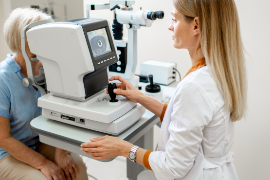 Ophthalmologist examining the eyes of an older patient using a digital microscope during a medical examination.