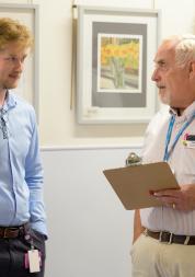 Two men stood chatting over a clipboard